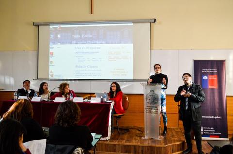 Panel de discusión con varios participantes en un aula.