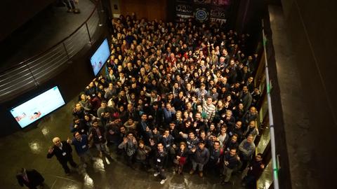 Una multitud de personas posando juntas en un evento en interiores.
