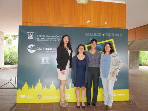 Cuatro mujeres posan frente a un fondo que promueve la calidad y equidad en la educación.
