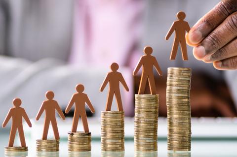 La imagen muestra figuras humanas de cartón sobre pilas de monedas, representando el crecimiento y la economía.