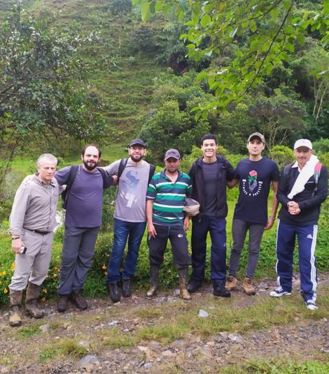 Un grupo de siete personas posando en un entorno natural montañoso.