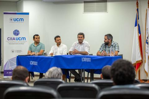 Una mesa redonda con cuatro personas sentadas frente a un público en un evento académico.