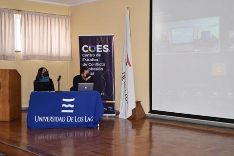 Dos personas sentadas frente a un ordenador en un evento en la Universidad de Los Lagos.