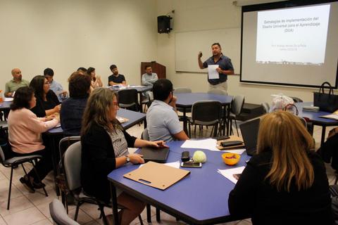 Una reunión en un aula donde un orador presenta sobre temas de educación inclusiva.