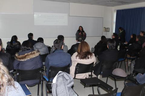 Una ponente presenta ante un público en un aula.