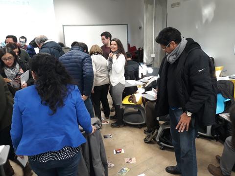 Un grupo de personas interactuando en un ambiente de trabajo, con algunas imágenes en el suelo.