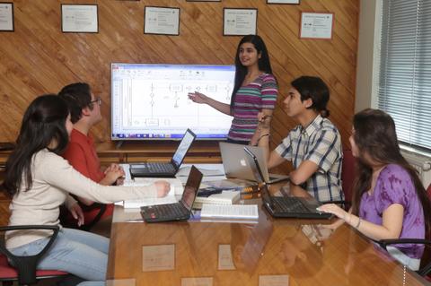 Un grupo de estudiantes participa en una presentación sobre un proyecto en un aula moderna.