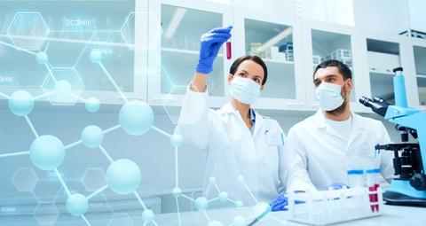 Dos científicos en un laboratorio observan un tubo de ensayo con una muestra de líquido.