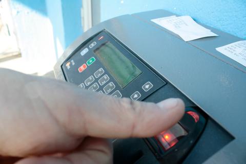 Una persona está usando un dispositivo que parece un terminal de pago con su huella dactilar.