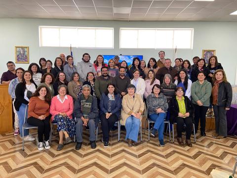 Un grupo grande de personas posando para una foto en un salón.