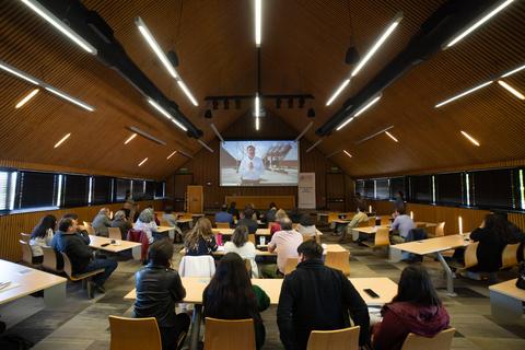 Una sala de conferencias con un grupo de personas frente a una pantalla de proyección.