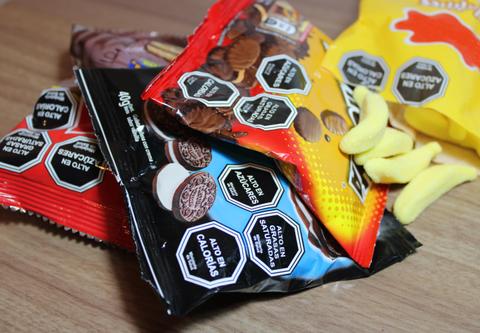 Una variedad de paquetes de golosinas y snacks sobre una superficie de madera.