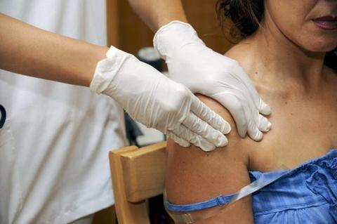 Una mujer está recibiendo una vacuna en el brazo.