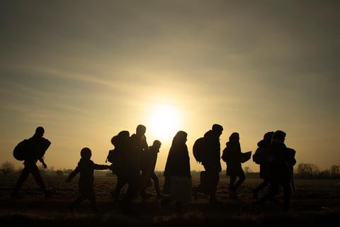 Un grupo de personas camina en un sendero bajo la luz del sol al amanecer.