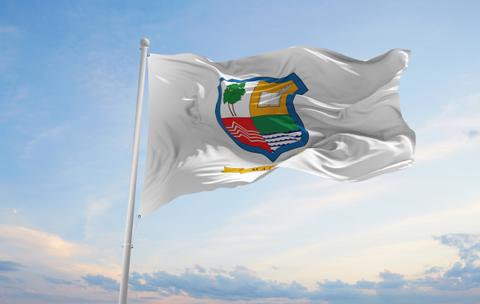 La bandera de la región de Magallanes ondeando al viento en un día soleado.