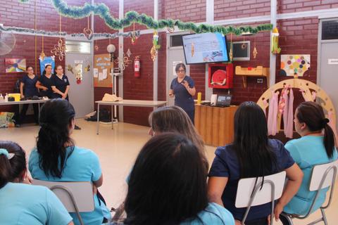 Una jornada de capacitación en un salón de clases con varias presencias femeninas atendiendo a una instructora.