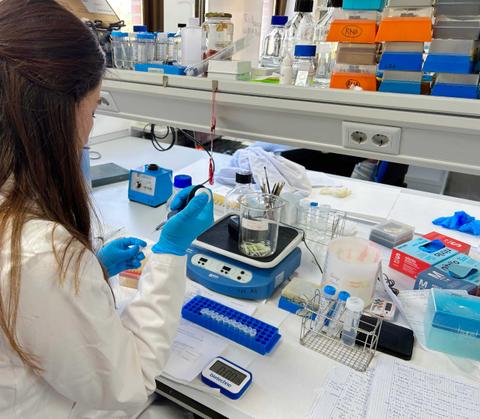 Una mujer en un laboratorio realiza experimentos con instrumentos científicos.