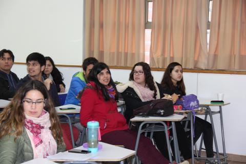 Un grupo de estudiantes sentados en un aula prestando atención.