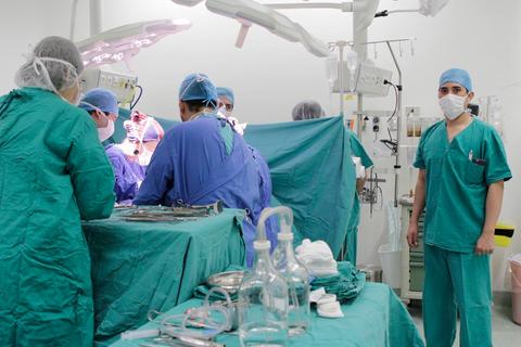 Un equipo médico opera a un paciente en un quirófano.