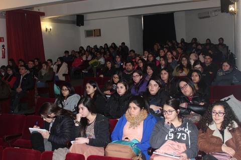La imagen muestra a un gran grupo de jóvenes sentados en un auditorio durante una conferencia o evento.