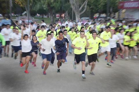 Un grupo de personas corriendo durante una carrera en un parque.