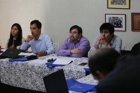 Un grupo de personas sentadas alrededor de una mesa en una reunión.