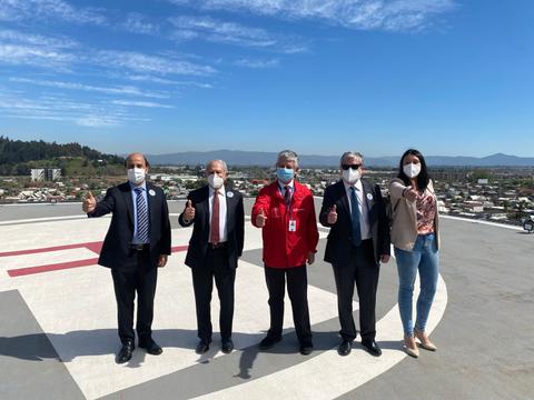 Grupo de personas posando en una azotea con vista panorámica, mostrando el pulgar hacia arriba.
