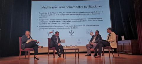 Un panel de discusión sobre la modificación de las normas sobre notificaciones electrónicas en un evento formal.