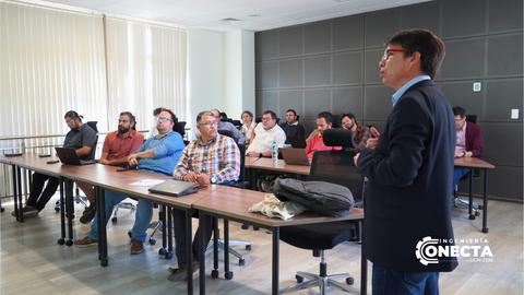 Un grupo de personas asiste a una presentación en una sala de clases.