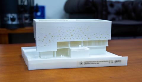Maqueta arquitectónica de un edificio moderno con detalles en relieve y un acabado blanco.