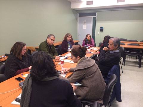 Un grupo de personas se reúne en una sala de conferencias para discutir o trabajar en equipo.