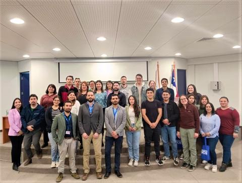 Un grupo diverso de personas posando para una foto en un evento en interiores.