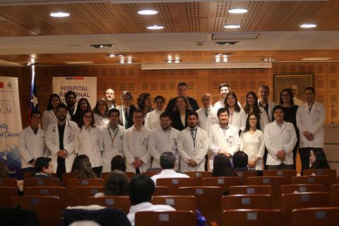 Un grupo de profesionales de la salud posando en un evento en un auditorio.