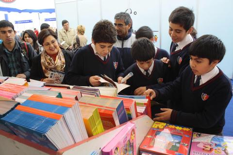 Un grupo de estudiantes revisa libros en una feria del libro.