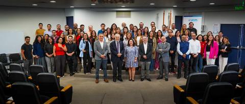 Un grupo grande de personas posando juntas en un auditorio.