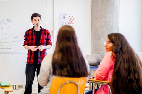 Un profesor expone frente a sus alumnos en un aula moderna.