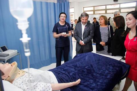 Un grupo de personas observa una demostración de un simulador médico en un entorno de hospital.