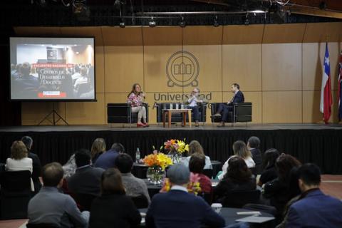 Un panel de discusión sobre derechos humanos en una universidad, con una audiencia atenta.