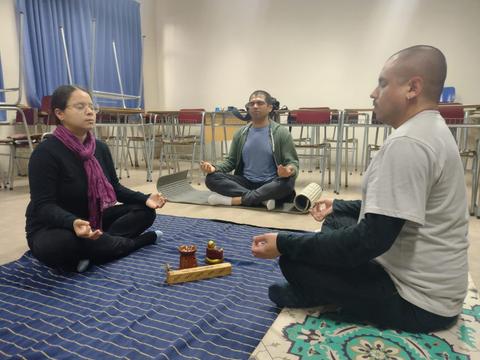 Un grupo de personas meditando en un ambiente tranquilo y relajante.