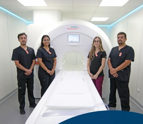 Cuatro profesionales de la salud posan junto a un equipo de resonancia magnética en un ambiente clínico moderno.