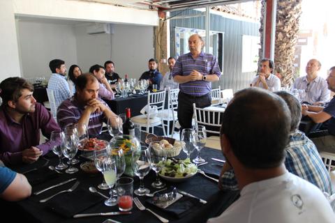 Un grupo de personas se encuentra en una reunión social en un ambiente de comida y bebida.