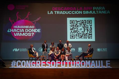 Un grupo de personas durante el Congreso Futuro en un escenario con una presentación sobre traducción simultánea.