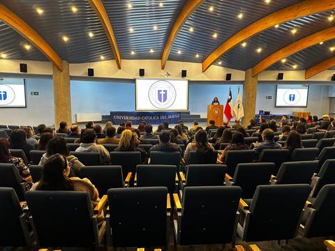 Una sala llena de personas en un evento en la Universidad Católica del Maule.