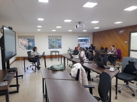 Una sala de clases con varias personas trabajando en sus computadoras portátiles.