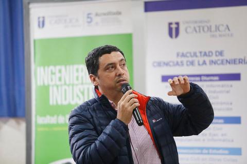 Un hombre habla con un micrófono en un evento académico.