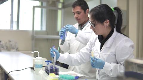 Dos personas trabajando en un laboratorio, realizando experimentos científicos.