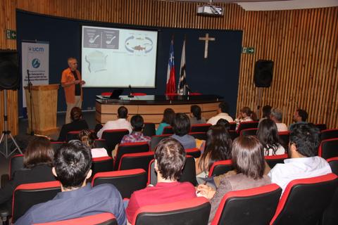 Una presentación en un auditorio donde un orador se dirige a un público atento.