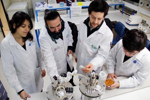 Un grupo de cuatro personas en un laboratorio, observando y manipulando equipos científicos.