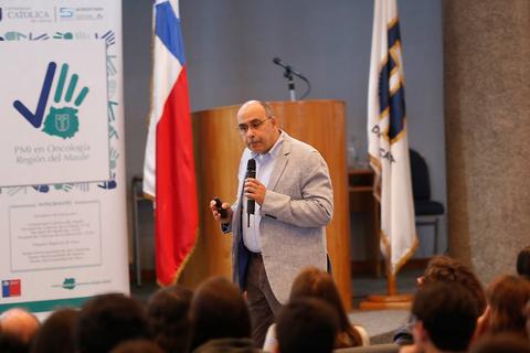 Un orador presenta en un evento frente a una audiencia en un auditorio.
