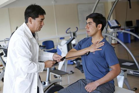 Un médico está revisando a un paciente en un centro de rehabilitación.